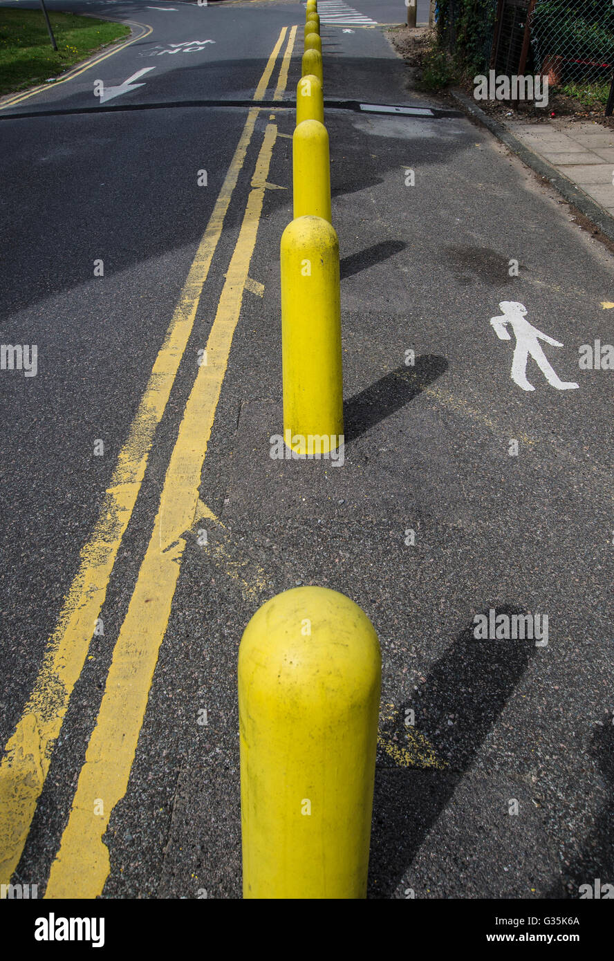 Yellow bollards and sign for pedestrians Stock Photo