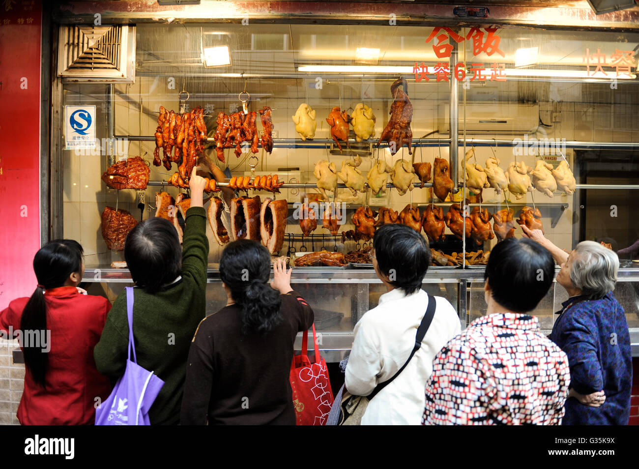 CHINA , Provinz Guangdong , Metropole Guangzhou (Kanton) Frauen vor einer Fleisch Theke / CHINA Guangzhou, women watch meat at a butchery Stock Photo
