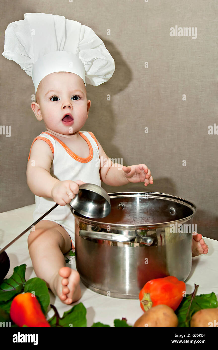 little baby in a chef's hat and ladle in hand Stock Photo