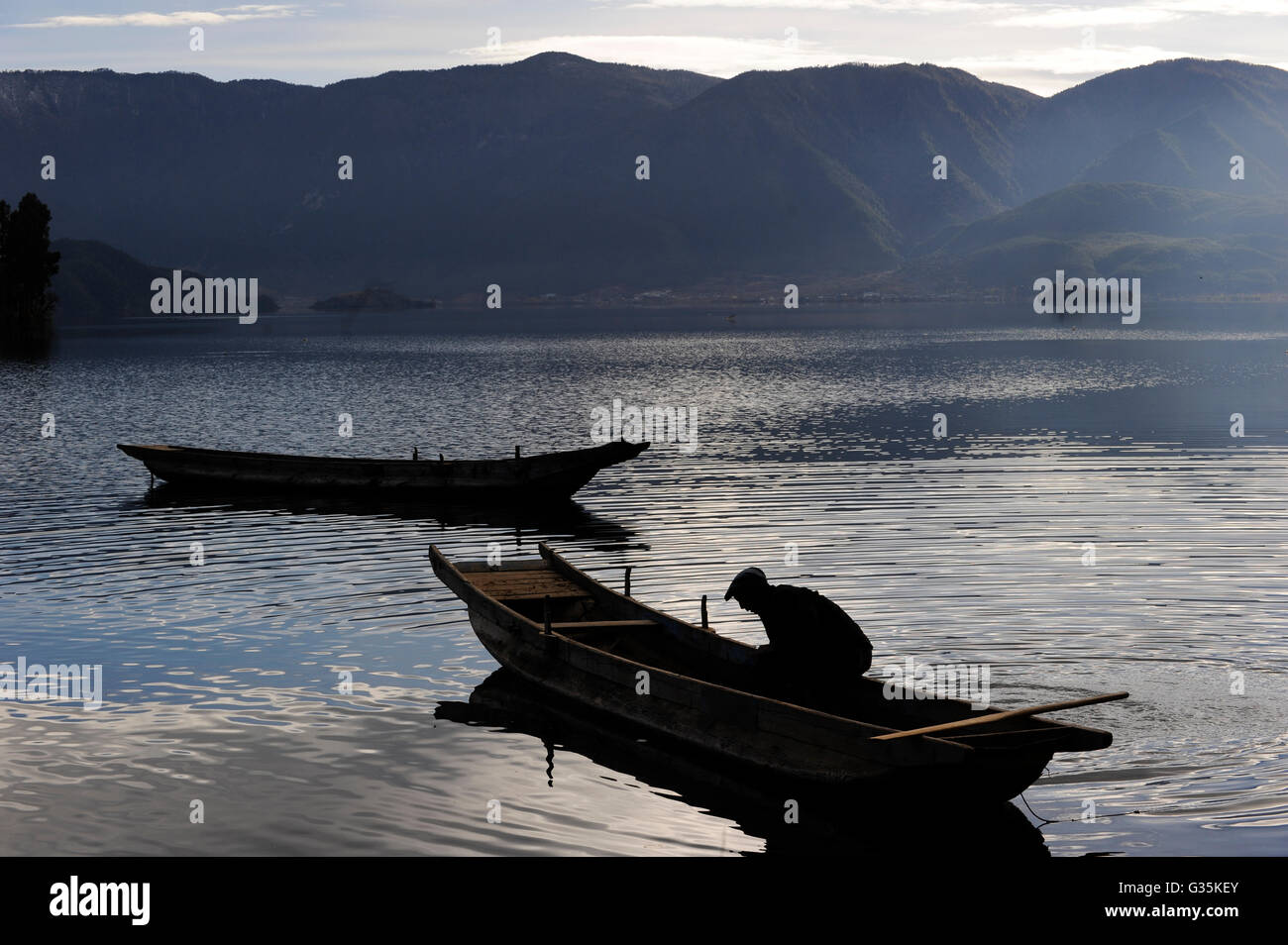 CHINA Yunnan boats at Lugu Lake , blue mood / CHINA Provinz Yunnan , Boote auf dem  Lugu See Stock Photo