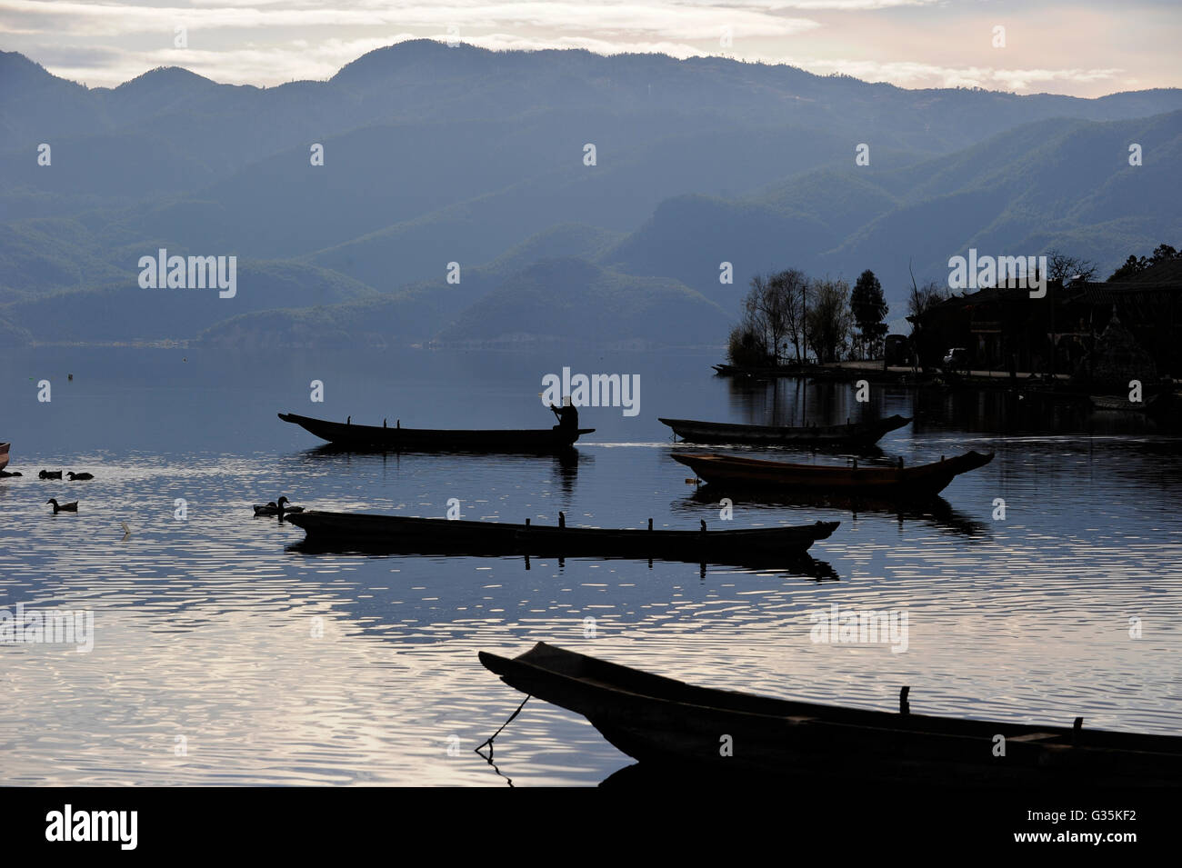 CHINA Yunnan boats at Lugu Lake , blue mood / CHINA Provinz Yunnan , Boote auf dem  Lugu See Stock Photo