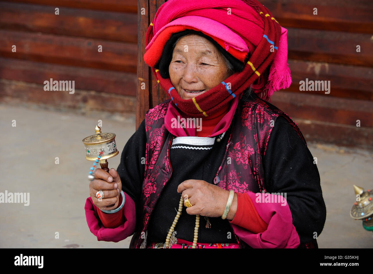 CHINA Yunnan, Lugu Lake , ethnic minority Mosuo who are buddhist and women have a matriarch, matriarchal society, old woman with prayer mill Stock Photo