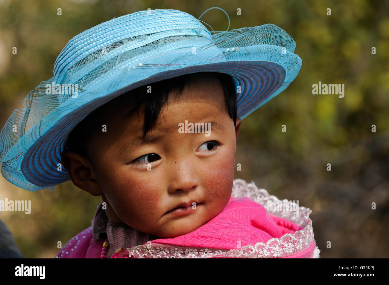 CHINA Yunnan Lugu Lake , ethnic minority Mosuo who are buddhist and women have a matriarch, matriarchal society, child with blue hat Stock Photo