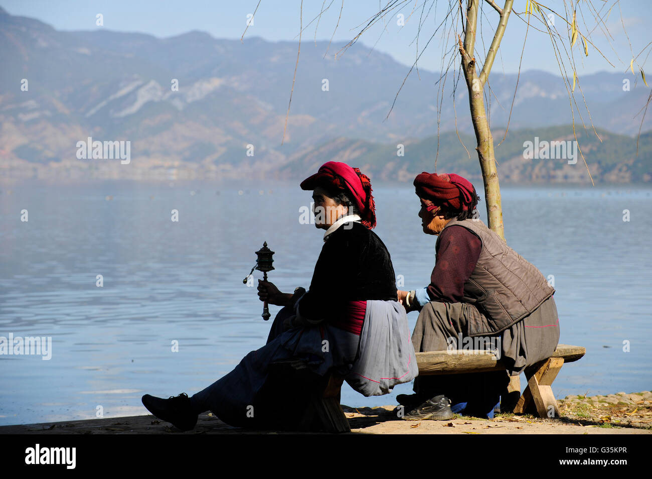 CHINA Yunnan, Lugu Lake , ethnic minority Mosuo who are buddhist and women have a matriarch, matriarchal society, woman with prayer mill Stock Photo