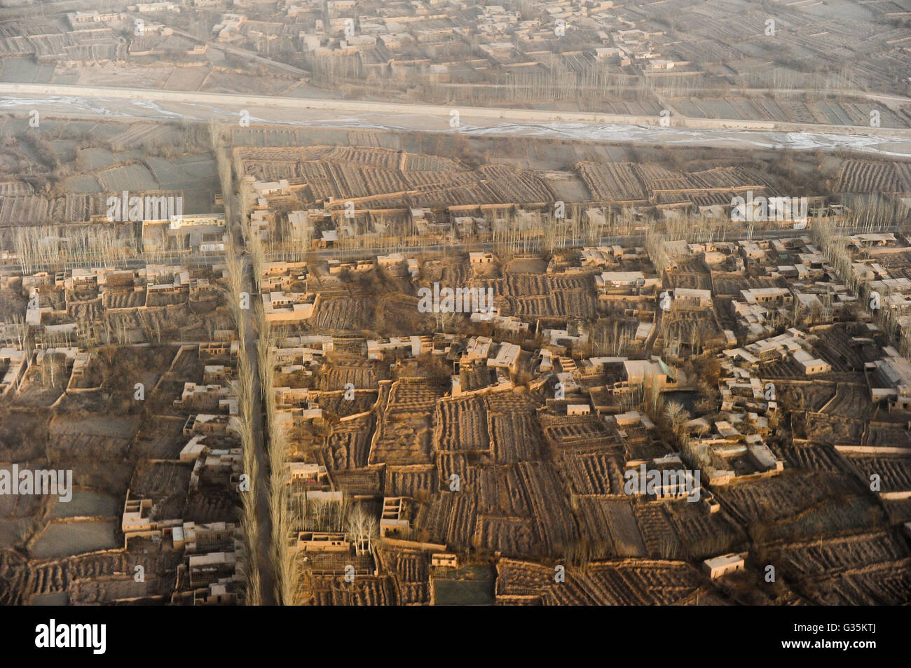 CHINA province Xinjiang, aerial view of city Kashgar and river Kashgar, where uyghur people are living, poplar tree avenues, fields and houses
