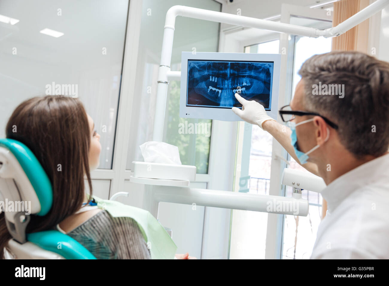 Male dentist shows a patient xray of teeth in clinic Stock Photo Alamy