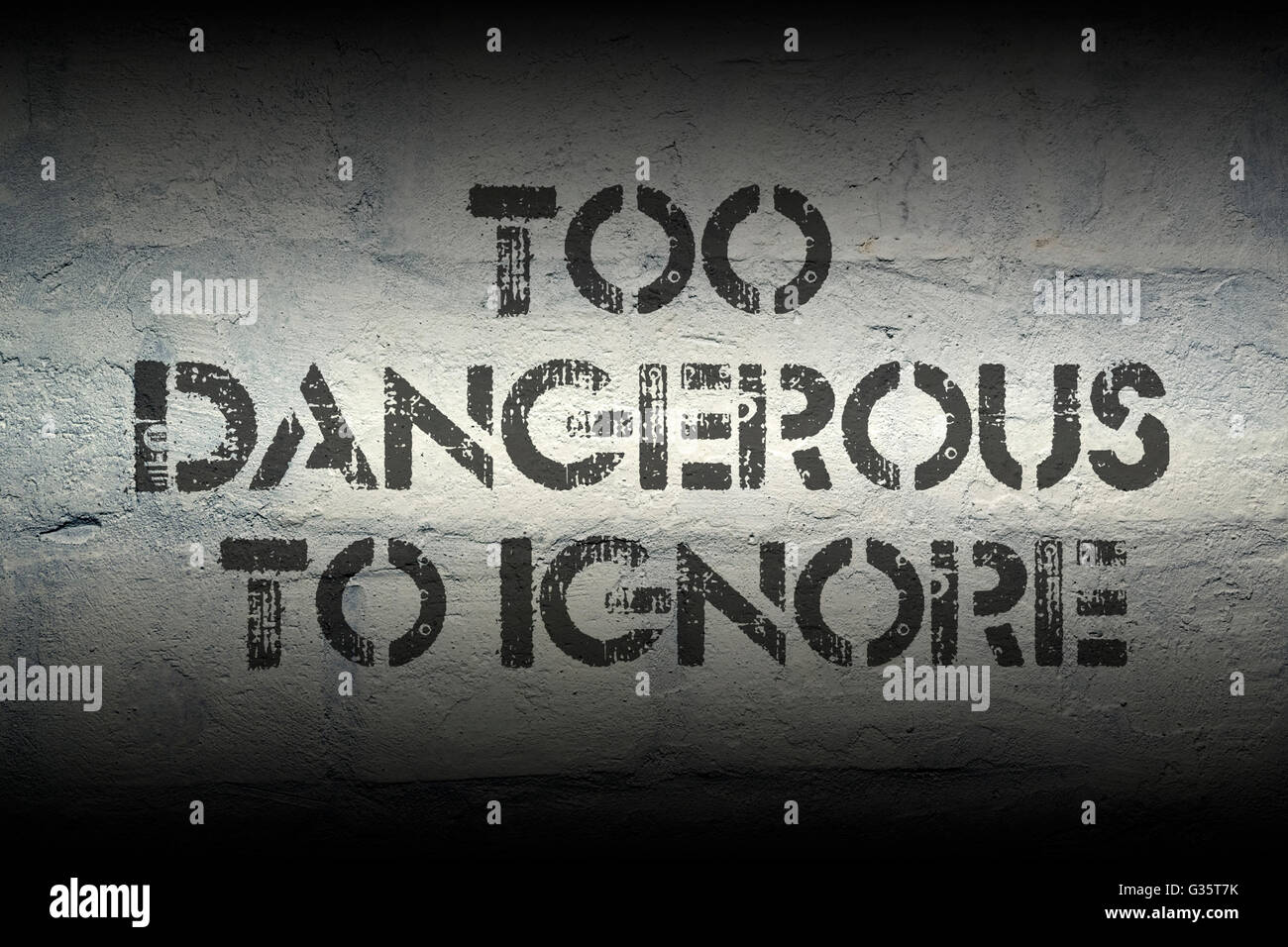 too dangerous to ignore stencil print on the grunge white brick wall Stock Photo