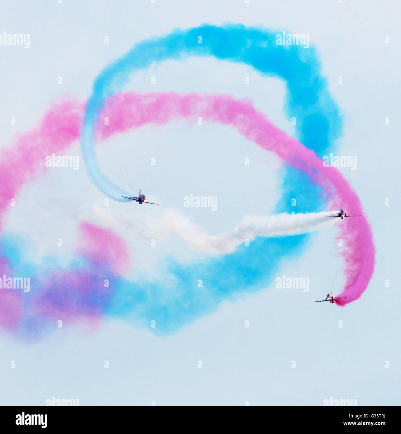 Three of the Red Arrows flying towards the camera in formation, with colourful smoke, Duxford Airshow, UK Stock Photo