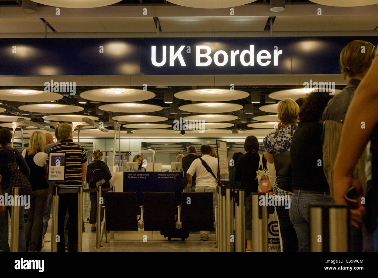 Queues of newly-arrived airline passengers line up to await their turn at the UK Border Agency's passport control at Heathrow Airport's Terminal 5. Immigration officers deal with each member of the public seeking entry into the United Kingdom but on average, 10 a day are refused entry at this London airport and between 2008 and 2009, 33,100 people were detained at the airport for mainly passport irregularities. The UK Border Agency is responsible for securing the United Kingdom borders and controlling migration in the UK. They manage border control enforcing immigration and customs regulations Stock Photo