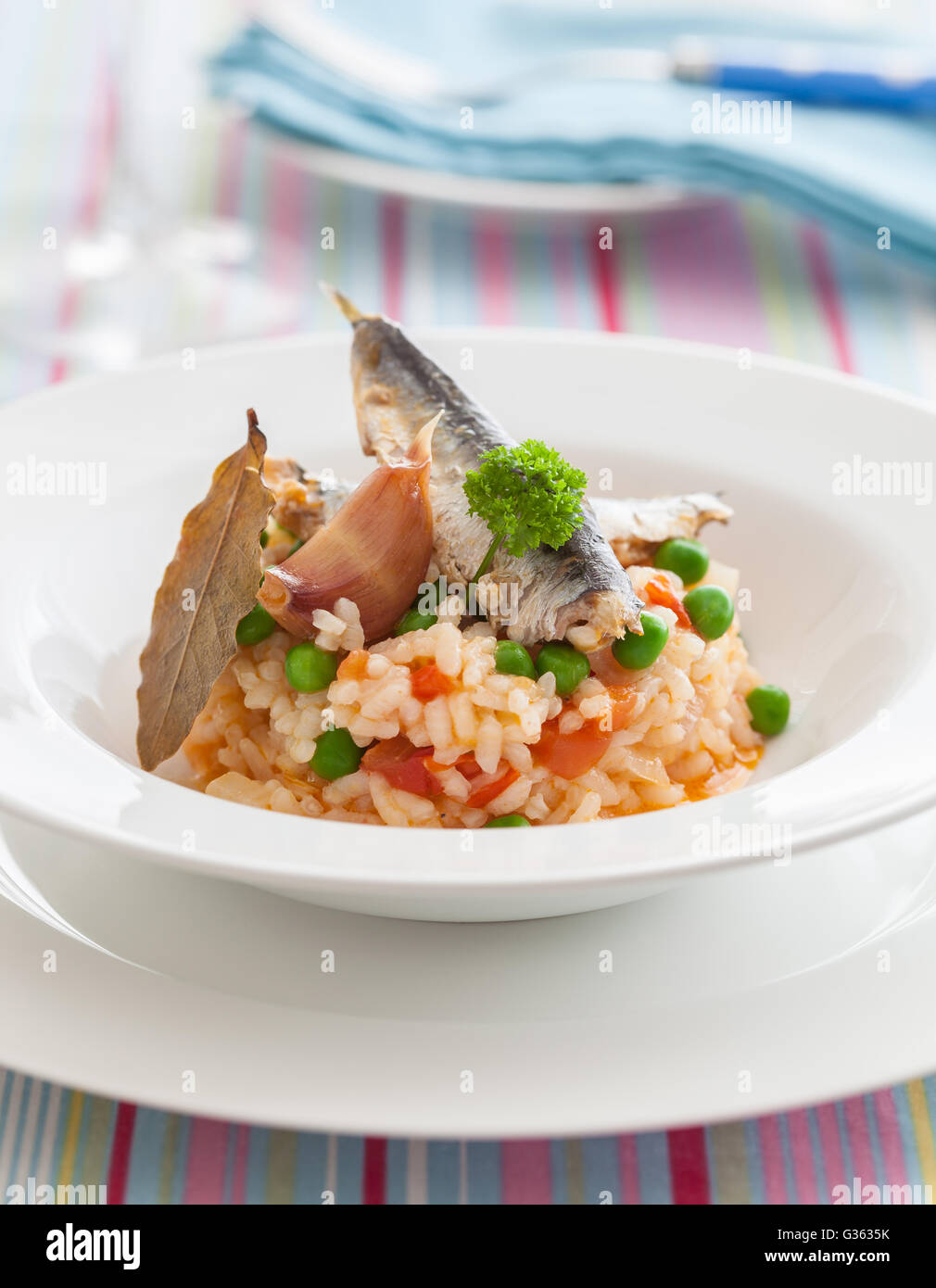 Rice with sardines, green peas, tomato, pepper, garlic and bay leaves