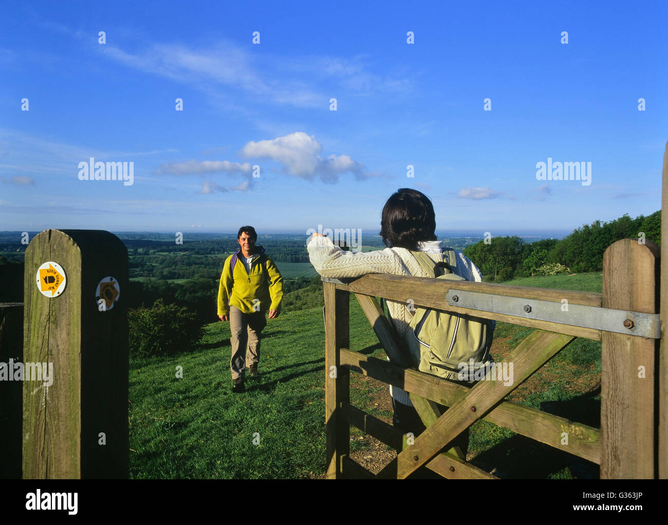 A young couple of adults walking the North Downs Way. Wye Downs. Kent. England. UK Stock Photo