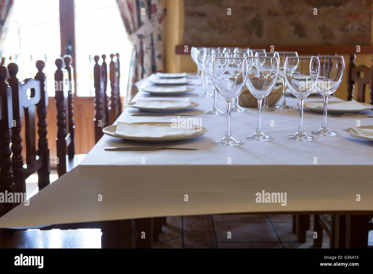 Table ready and waiting for the guests to arrive at a rustic restaurant Stock Photo