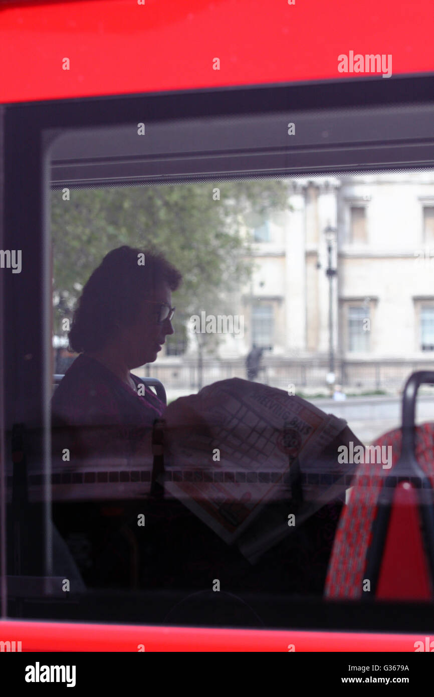 A view of a woman reading a newspaper on a bus in Trafalgar Square, London, England. Stock Photo