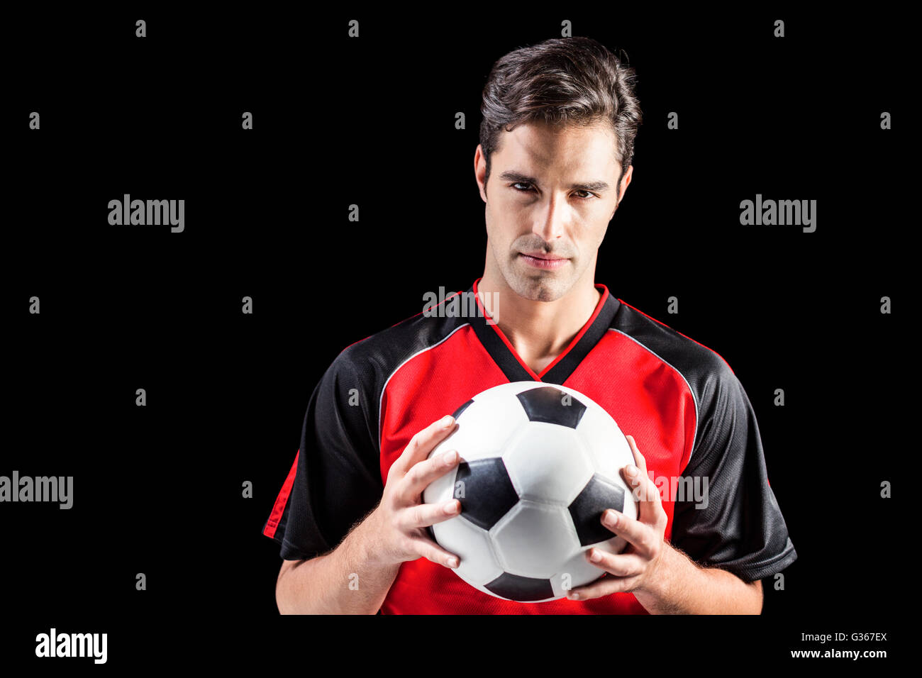 Portrait of confident male athlete holding football Stock Photo