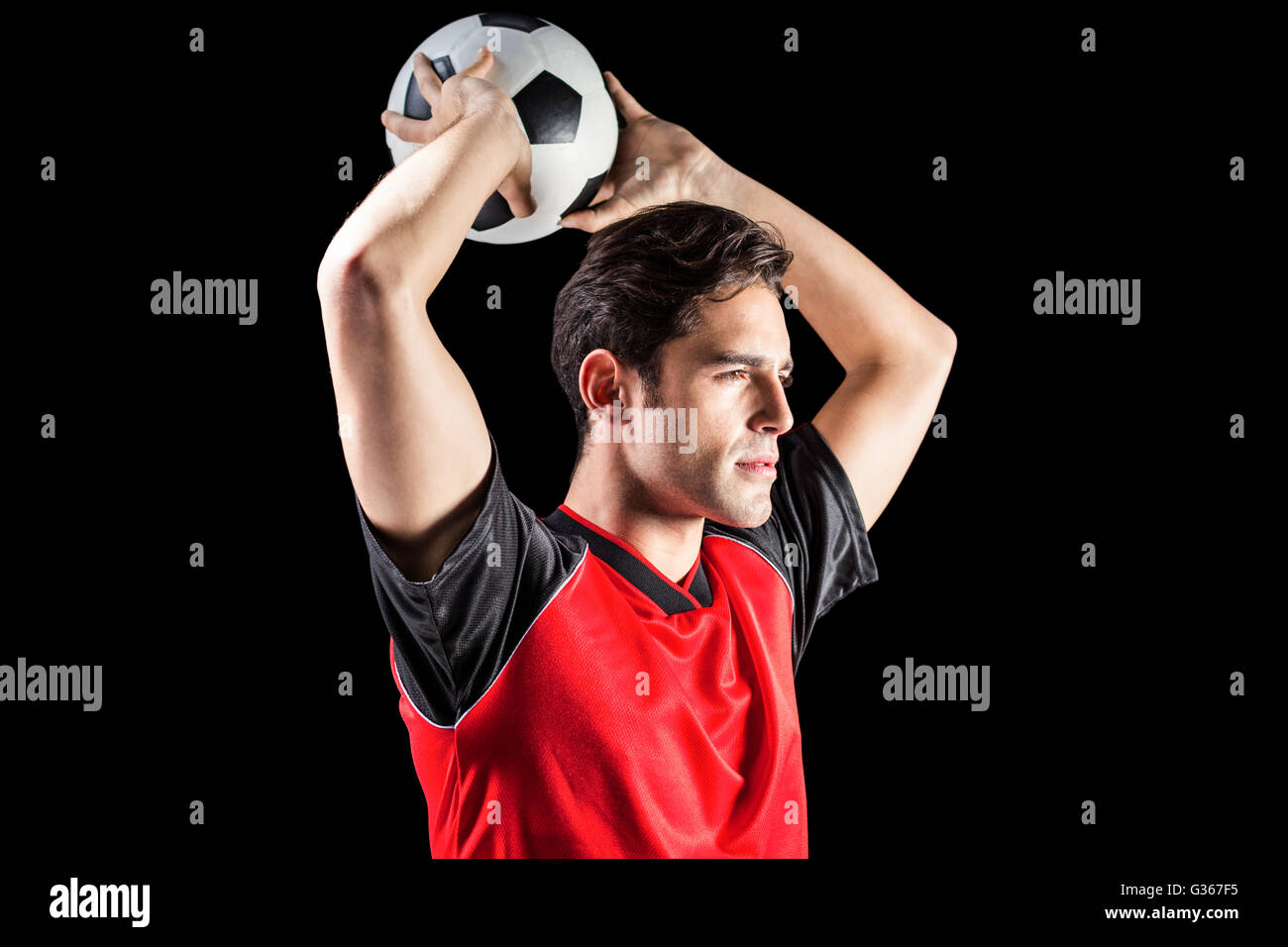 Confident male athlete throwing football Stock Photo