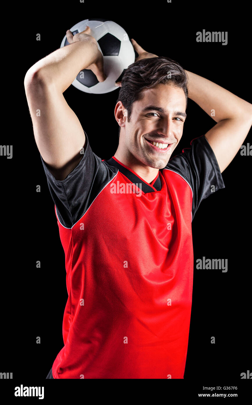 Portrait of happy male athlete throwing football Stock Photo