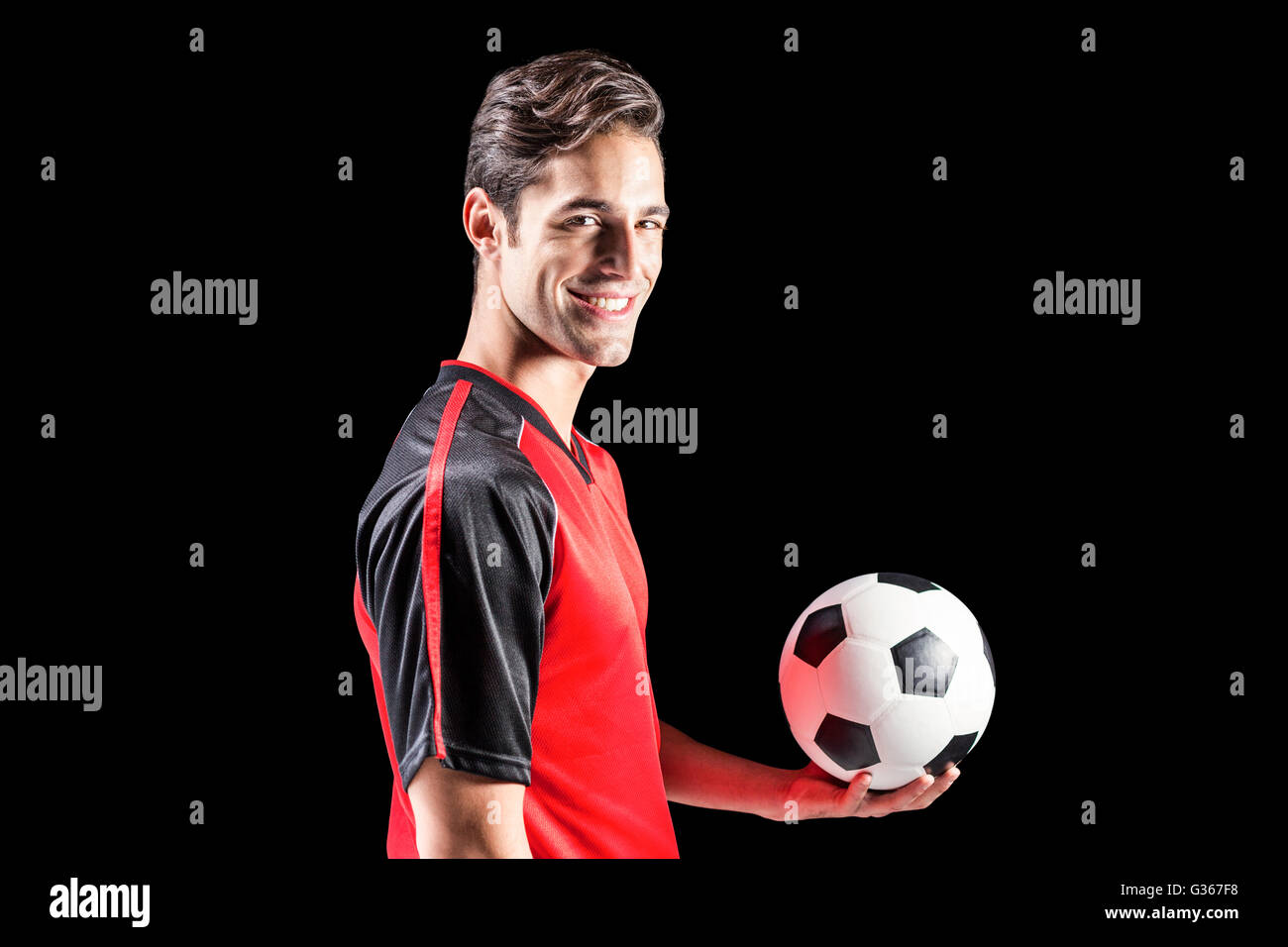 Portrait of happy male athlete holding football Stock Photo