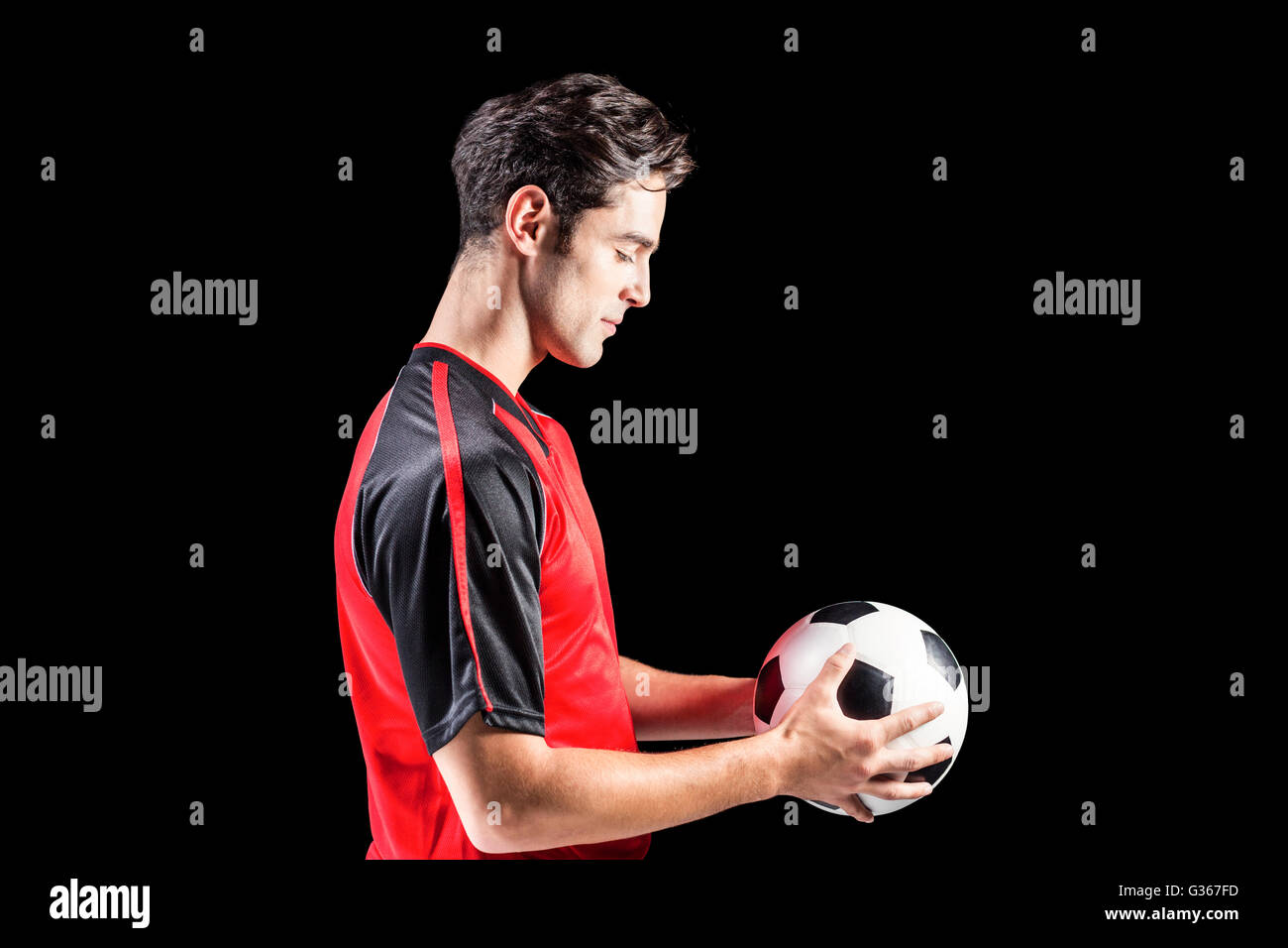 Confident male athlete holding football Stock Photo