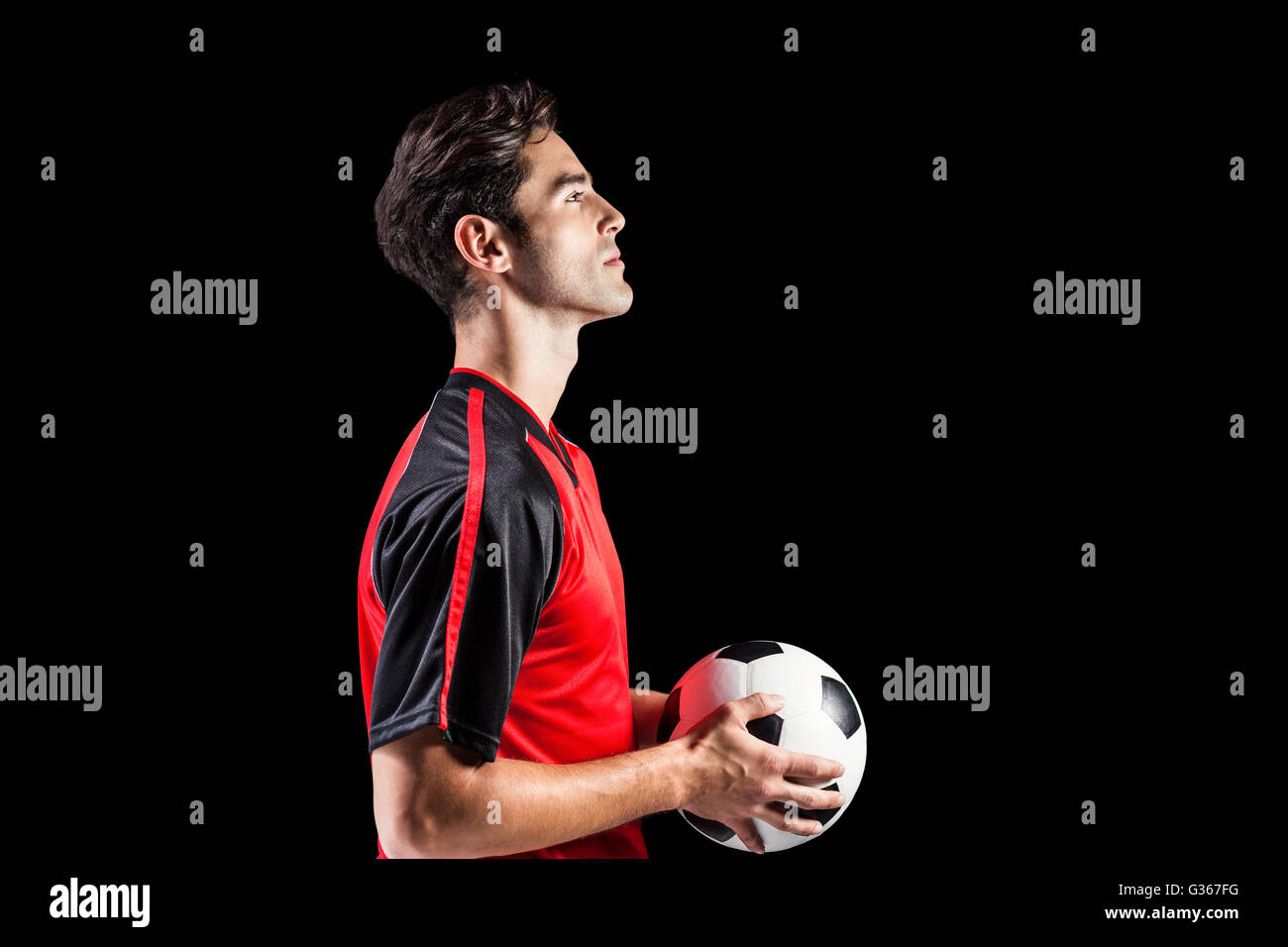 Confident male athlete holding football Stock Photo