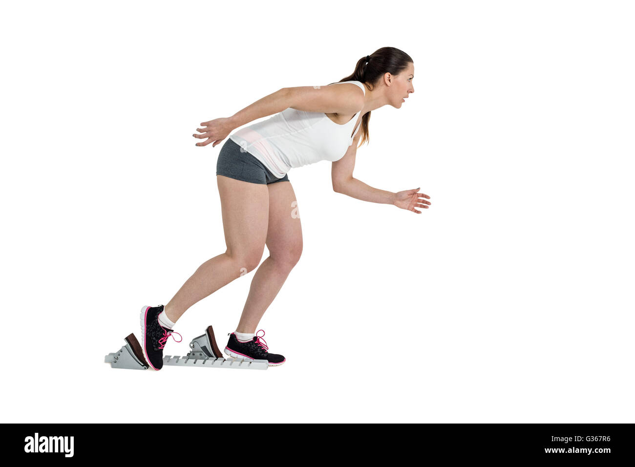 Confident athlete woman running from starting blocks Stock Photo