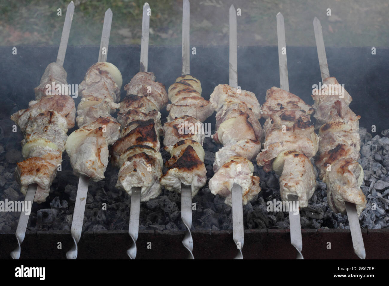 Shish kebab on the skewers in the smoke photo Stock Photo