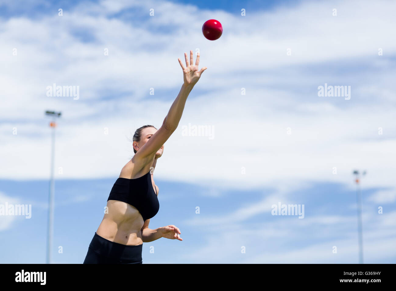Confident female athlete throwing shot put ball Stock Photo Alamy