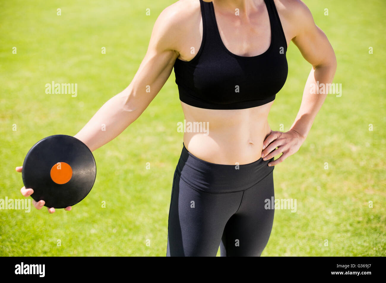 Mid section of female athlete about to throw a discus Stock Photo