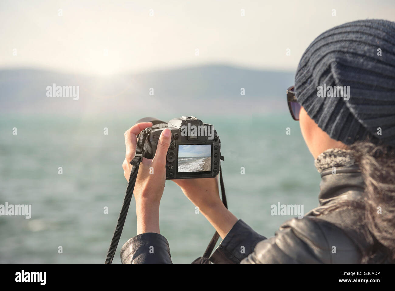 Woman shoots at camera sea landscape at sunset Stock Photo - Alamy