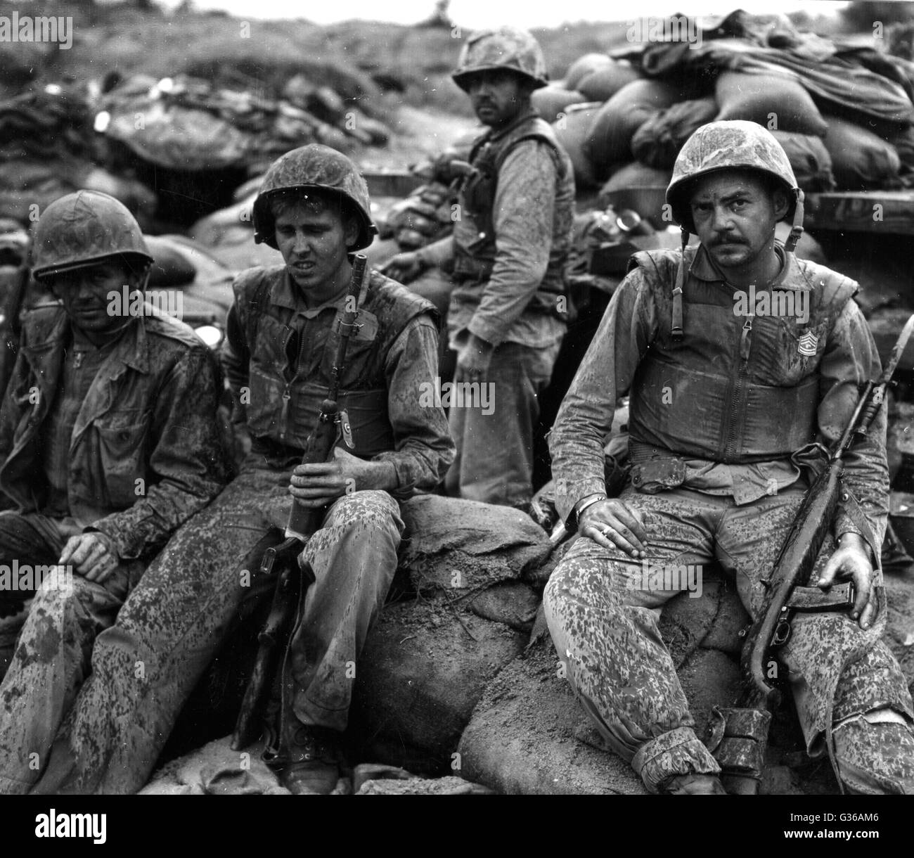 Tired Marines with F Company, First Marine Regiment take a break during a lull in the fighting on Bunker Hill during the Korean War. Stock Photo