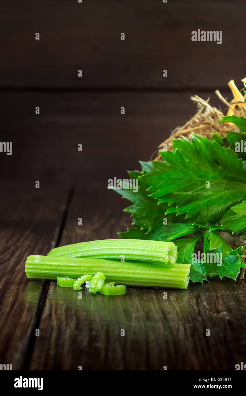 Celery leaves and sticks on dark wooden background. Copy space Stock Photo
