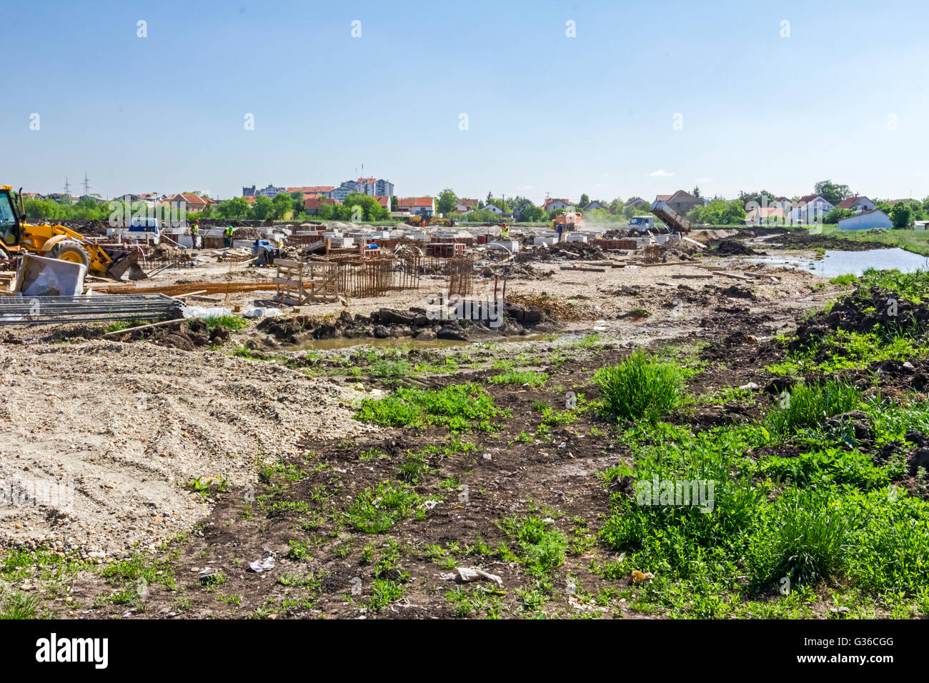 Landscape transform into urban area with machinery, people are working. View on construction site. Stock Photo