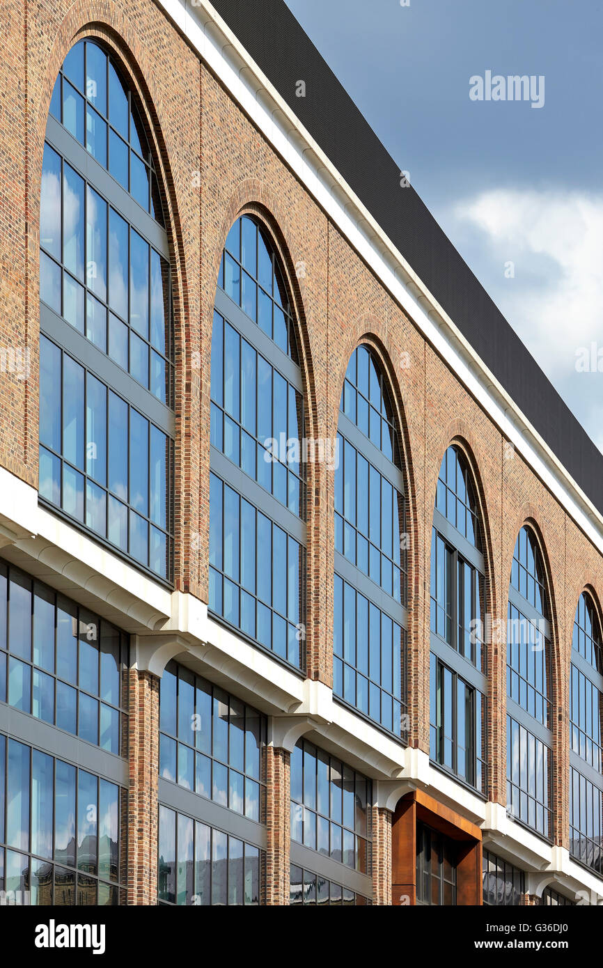 Facade detail with arched windows. Commodity Quay, London, United Kingdom. Architect: BuckleyGrayYeoman, 2014. Stock Photo