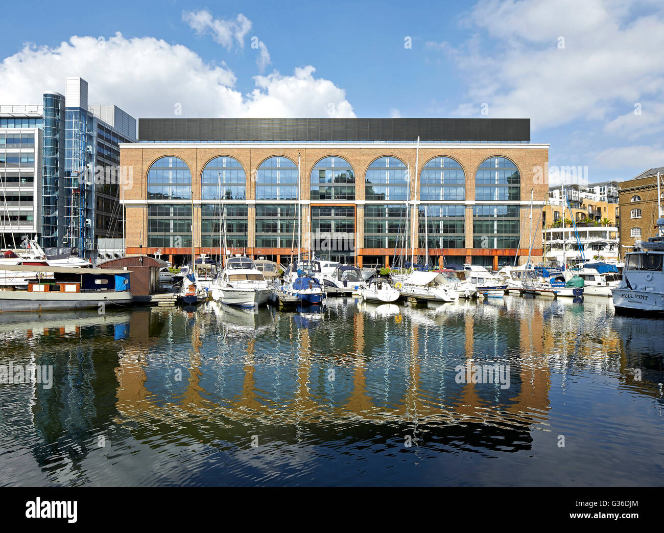 View across marina towards refurbished office building. Commodity Quay, London, United Kingdom. Architect: BuckleyGrayYeoman, 2014. Stock Photo
