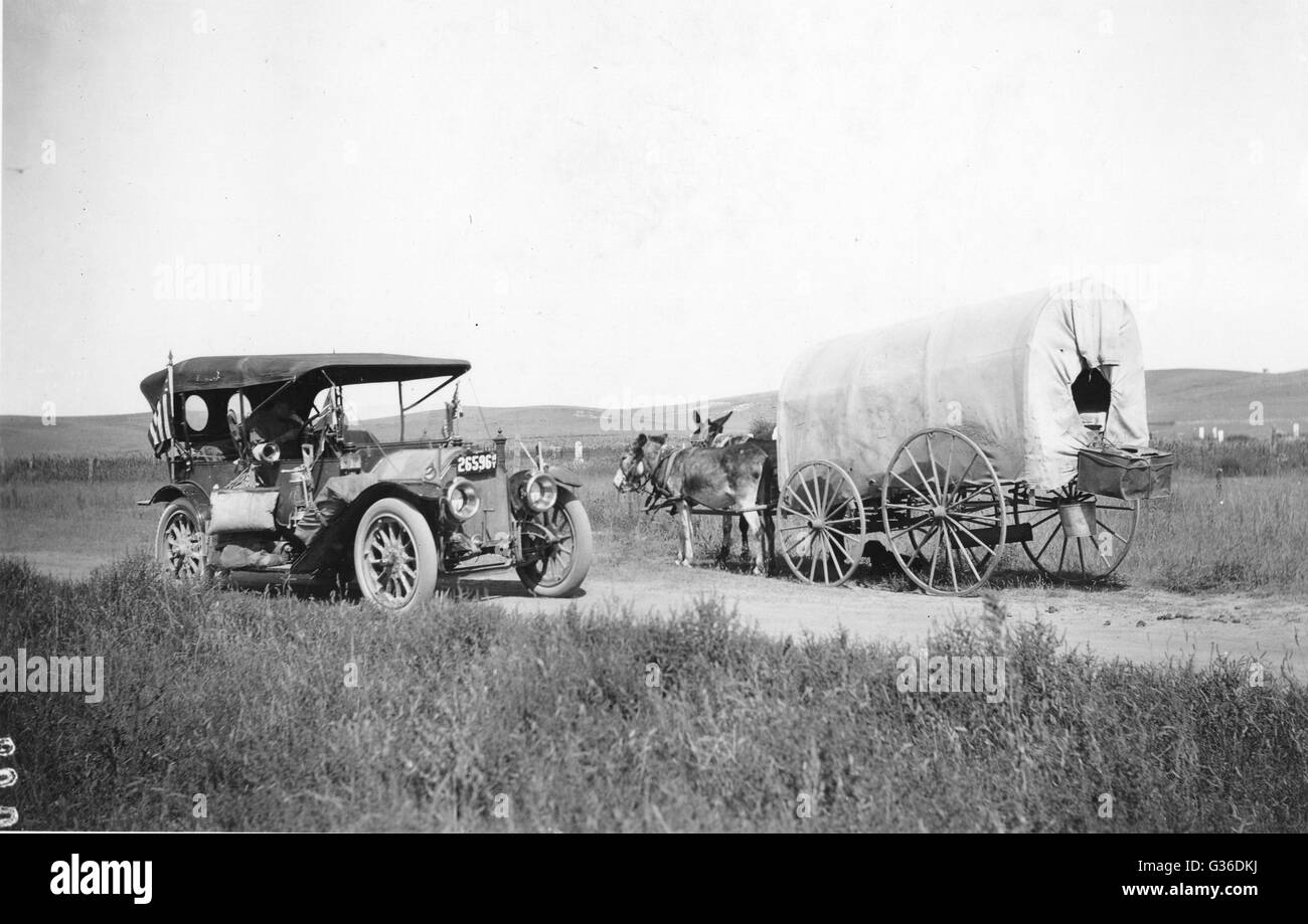 Comparison of a Covered Wagon with jackrabbit mules and automobile showing the Evolution of Transportation. Stock Photo