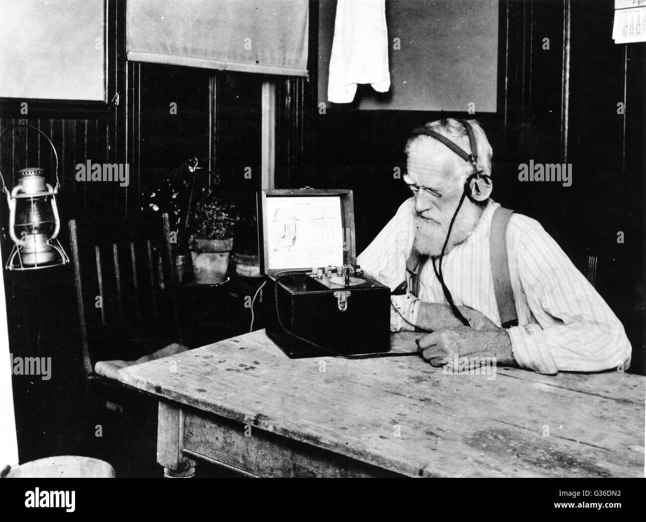 Early days of radio : Radio market news goes out to even the most isolated farms. Listening in on a crystal detector set to radio market news broadcast from Washington, DC. Stock Photo