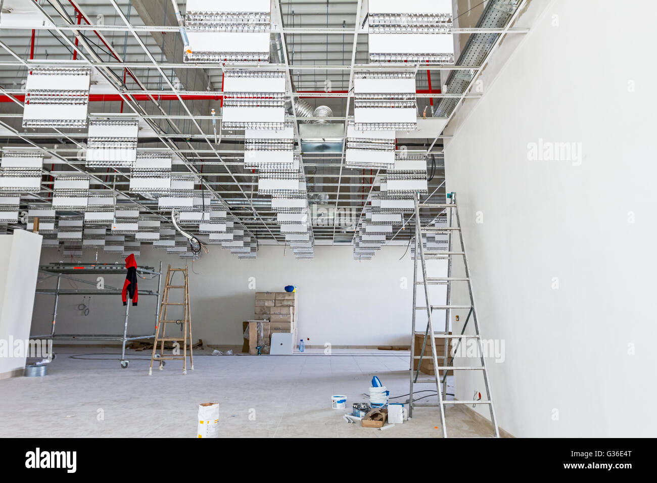 Workers are used wooden ladder to complete suspended office ceiling at