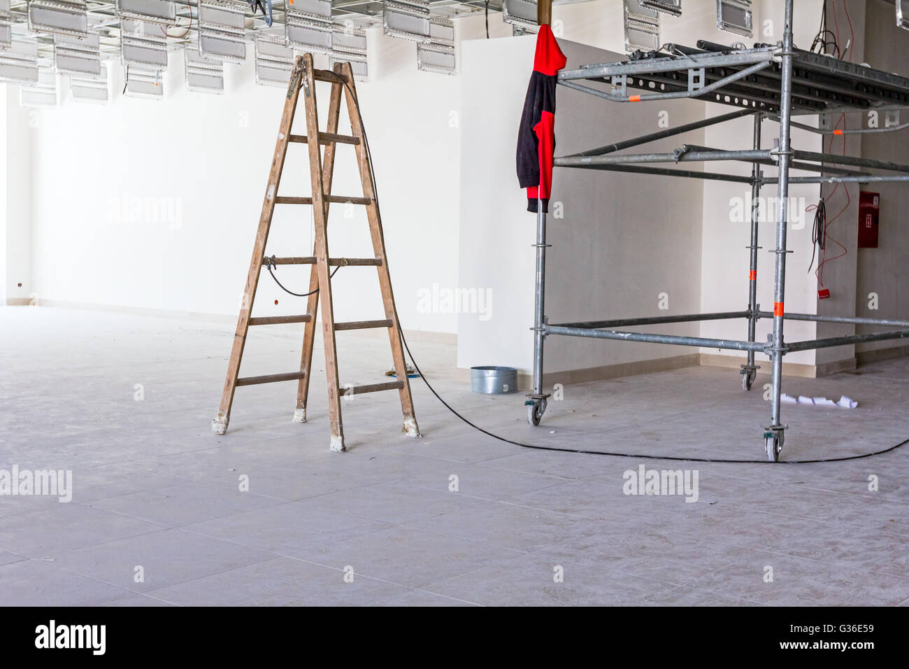 Workers are used wooden ladder to complete suspended office ceiling at