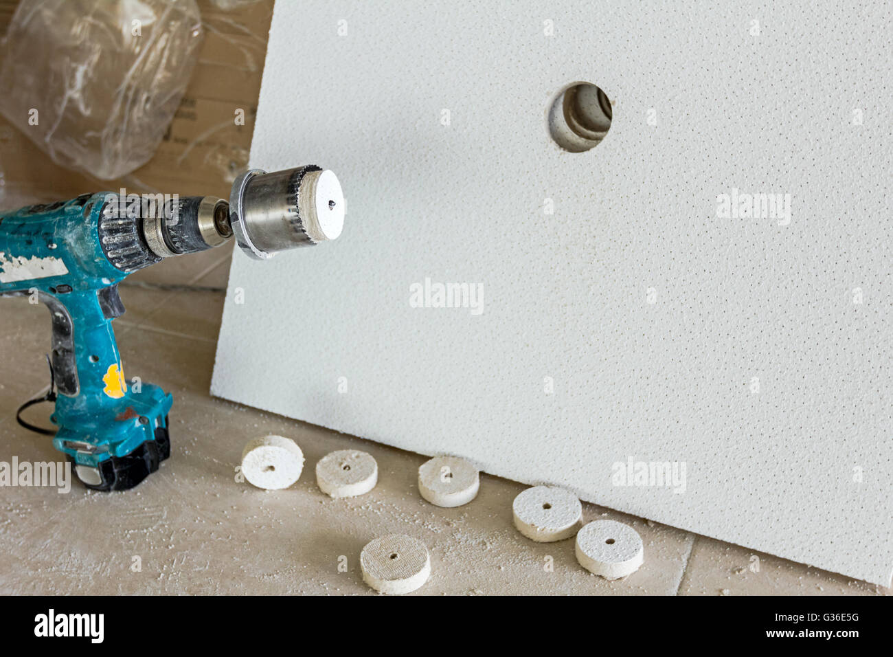 Precision drilling a hole with hole saw trough plasterboard. Stock Photo