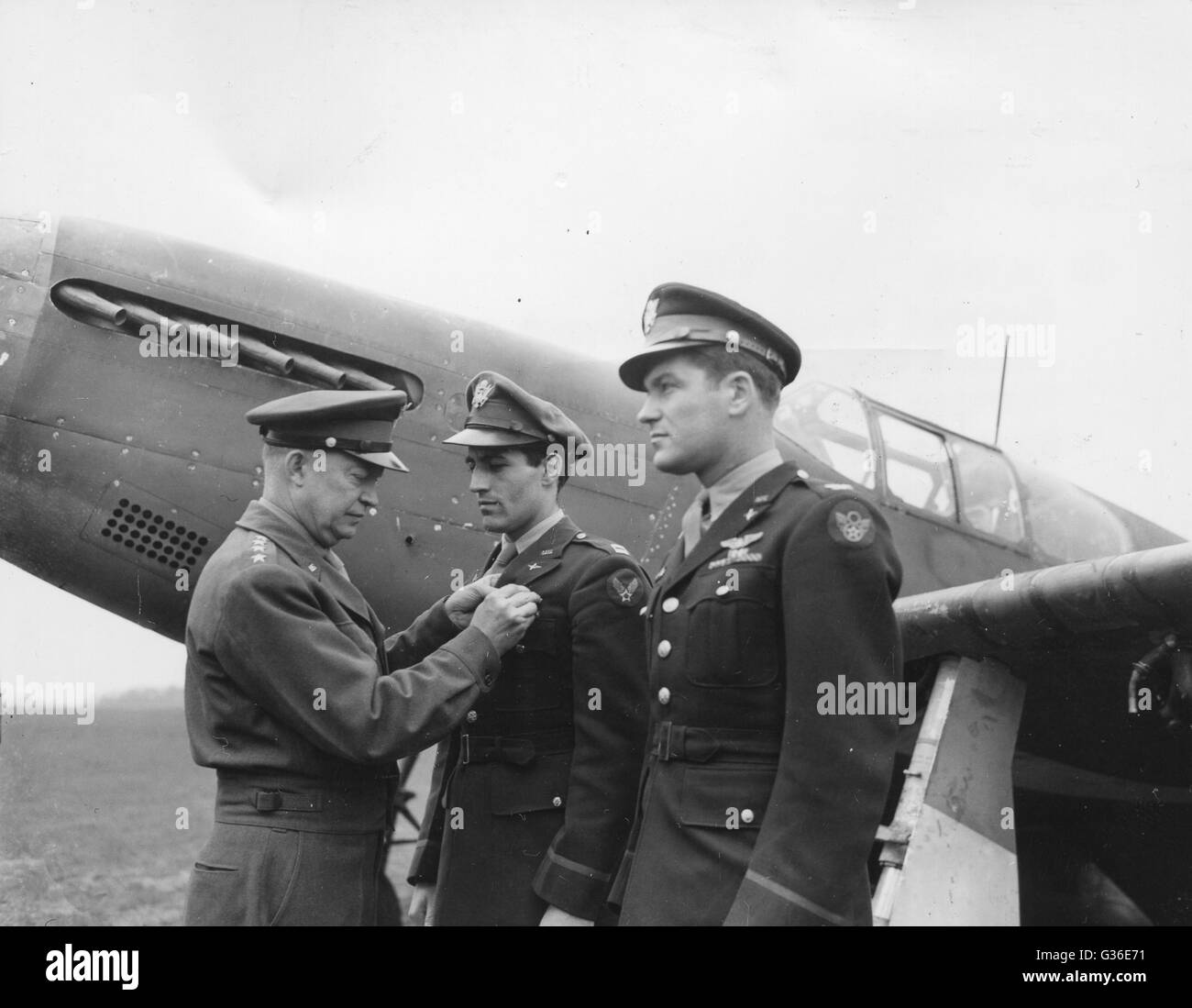 General Dwight D. Eisenhower, Supreme Allied Commander, pins the Distinguished Service Cross to the blouse of Capt. Donald Gentile. On the right is Col Donald Blakeslee, who also received the DSO. Stock Photo
