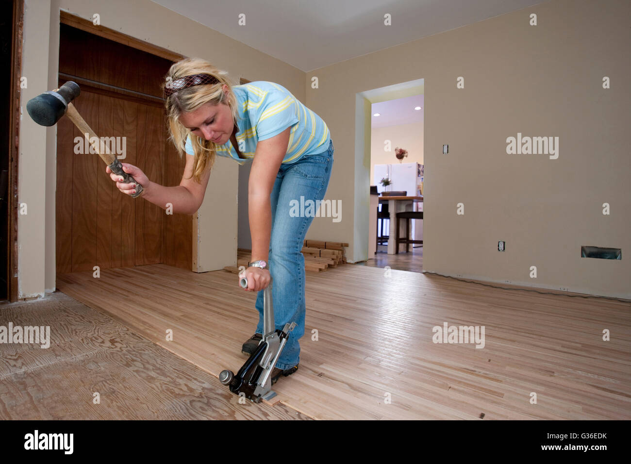 female carpenter nailing oak flooring Stock Photo Alamy