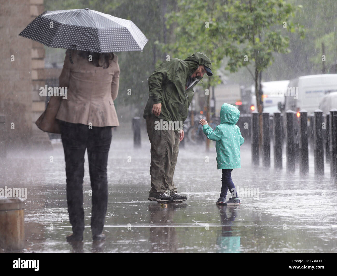 People are caught out in a heavy rain shower in Westminster, London