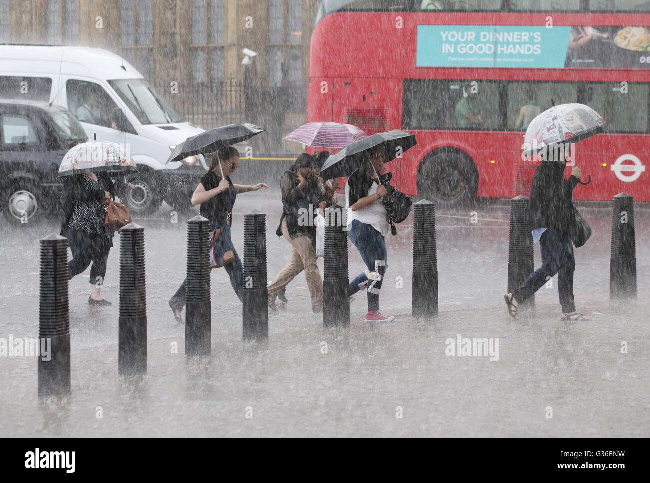 People are caught out in a heavy rain shower in Westminster, London