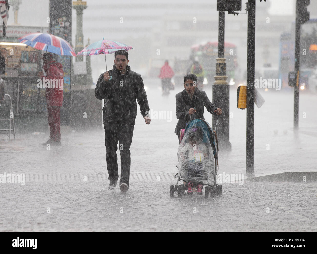People are caught out in a heavy rain shower in Westminster, London