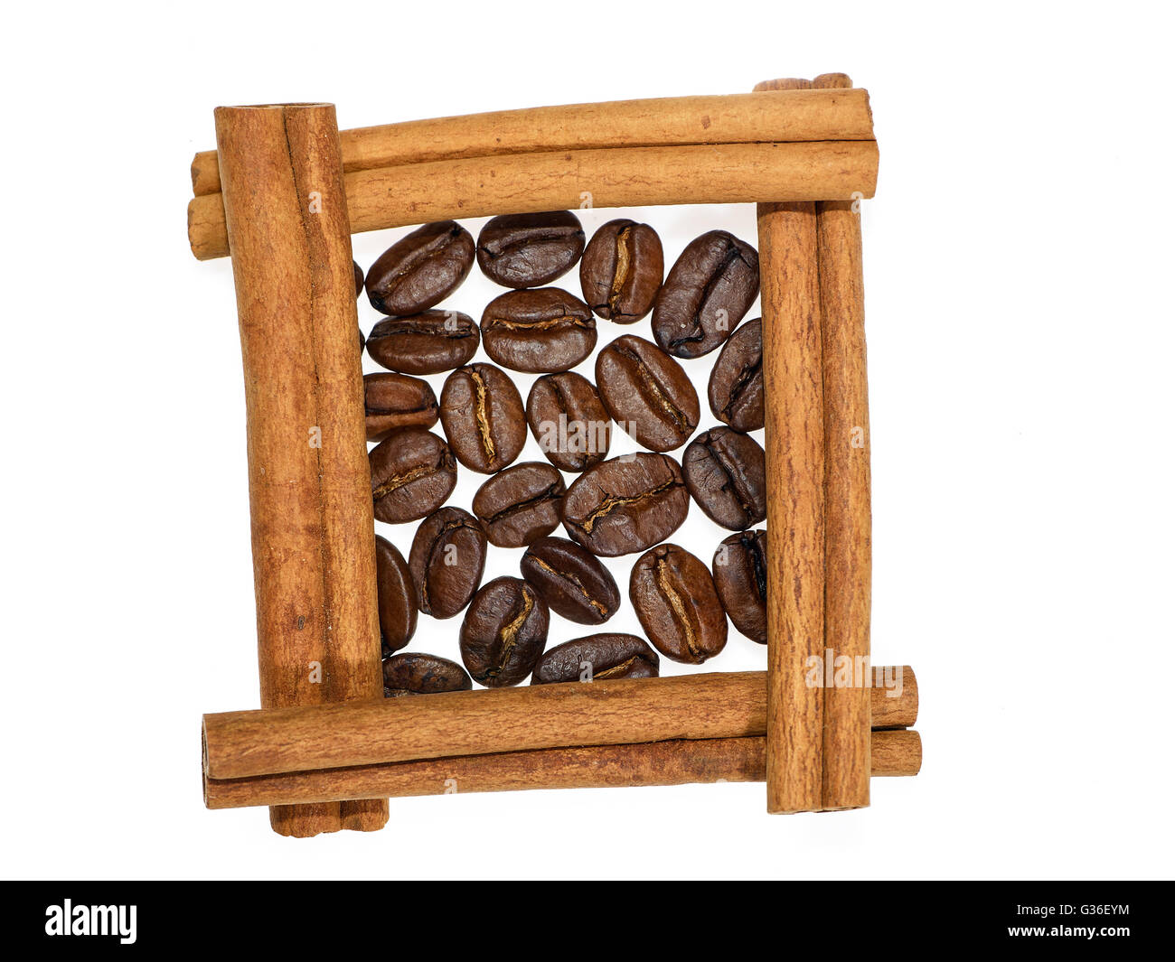 Roasted coffee beans in square of cinnamon sticks on white background Stock Photo