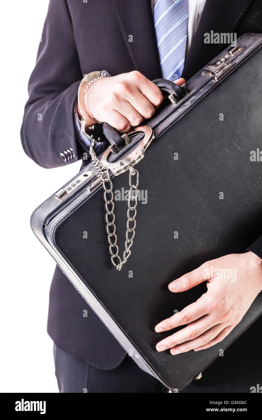 Businessman wearing a suit with a secure suitcase attached with handcuffs isolated over a white background Stock Photo