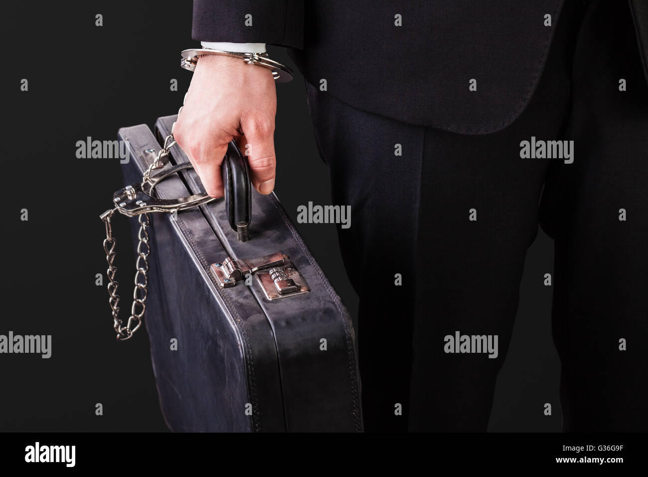 Businessman wearing a suit with a secure suitcase attached with handcuffs Stock Photo