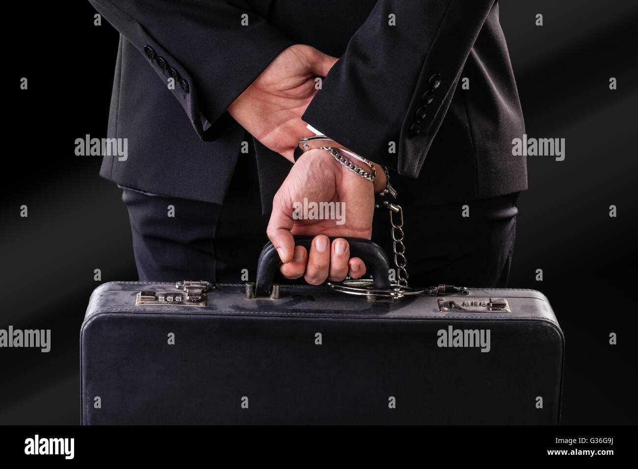 Businessman wearing a suit with a secure suitcase attached with