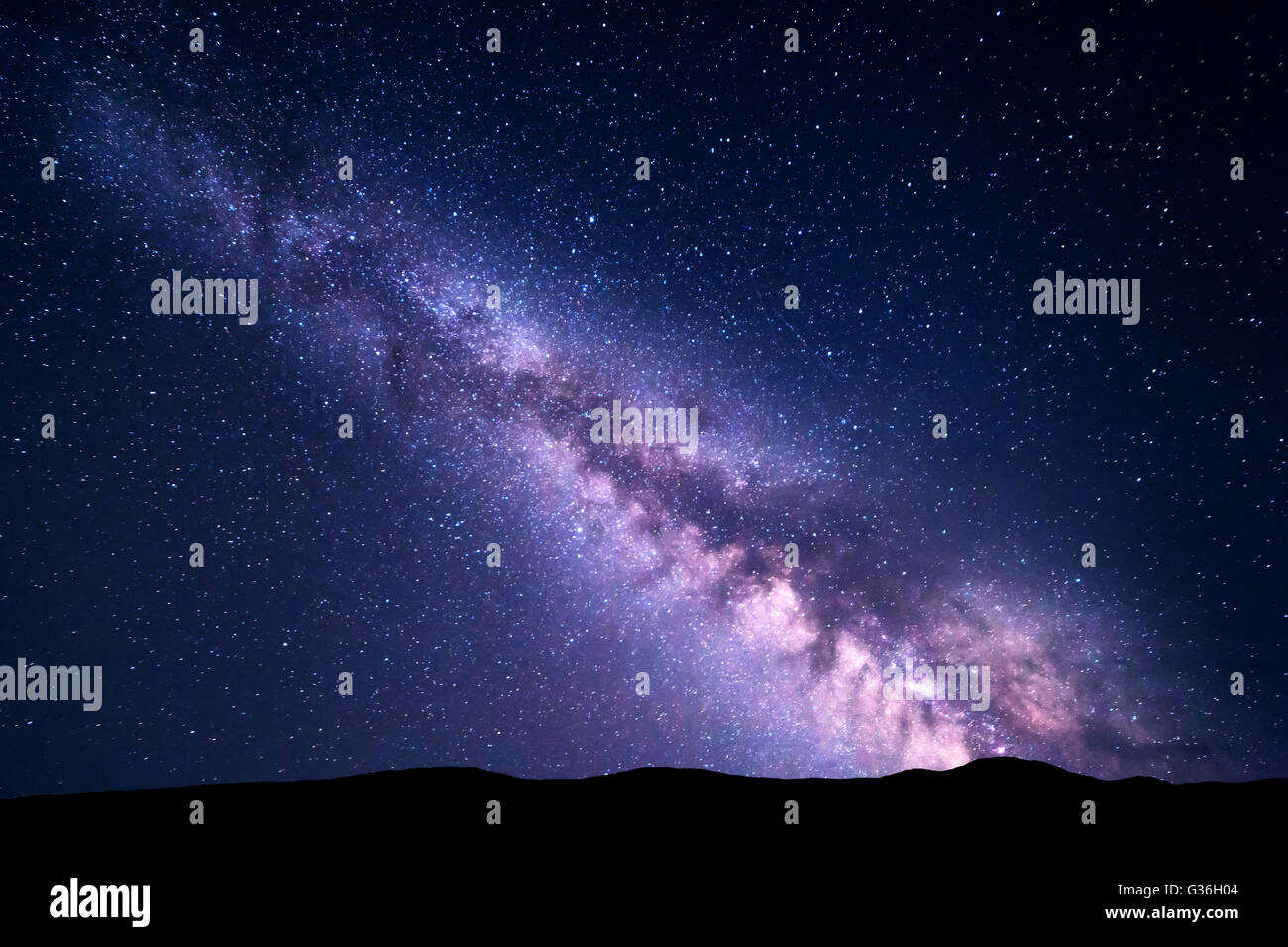 Landscape with purple Milky Way. Night sky with stars and hills at summer. Beautiful universe. Space background Stock Photo