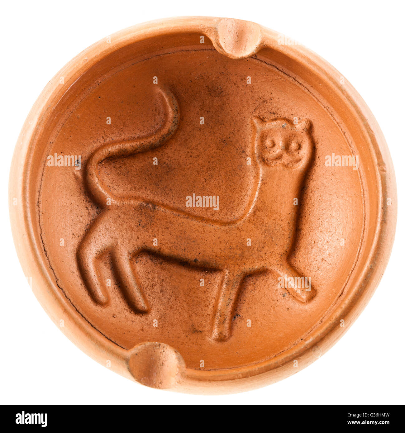a clay ashtray with a cat figure engraved on it isolated over a white background Stock Photo