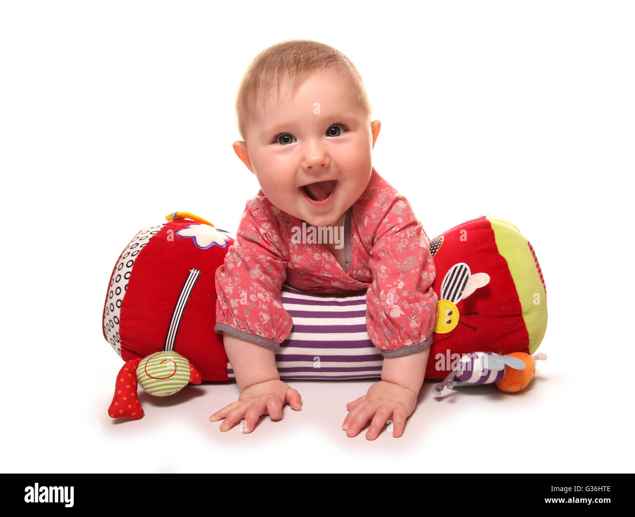 baby girl playing on a tummy time roll cutout Stock Photo
